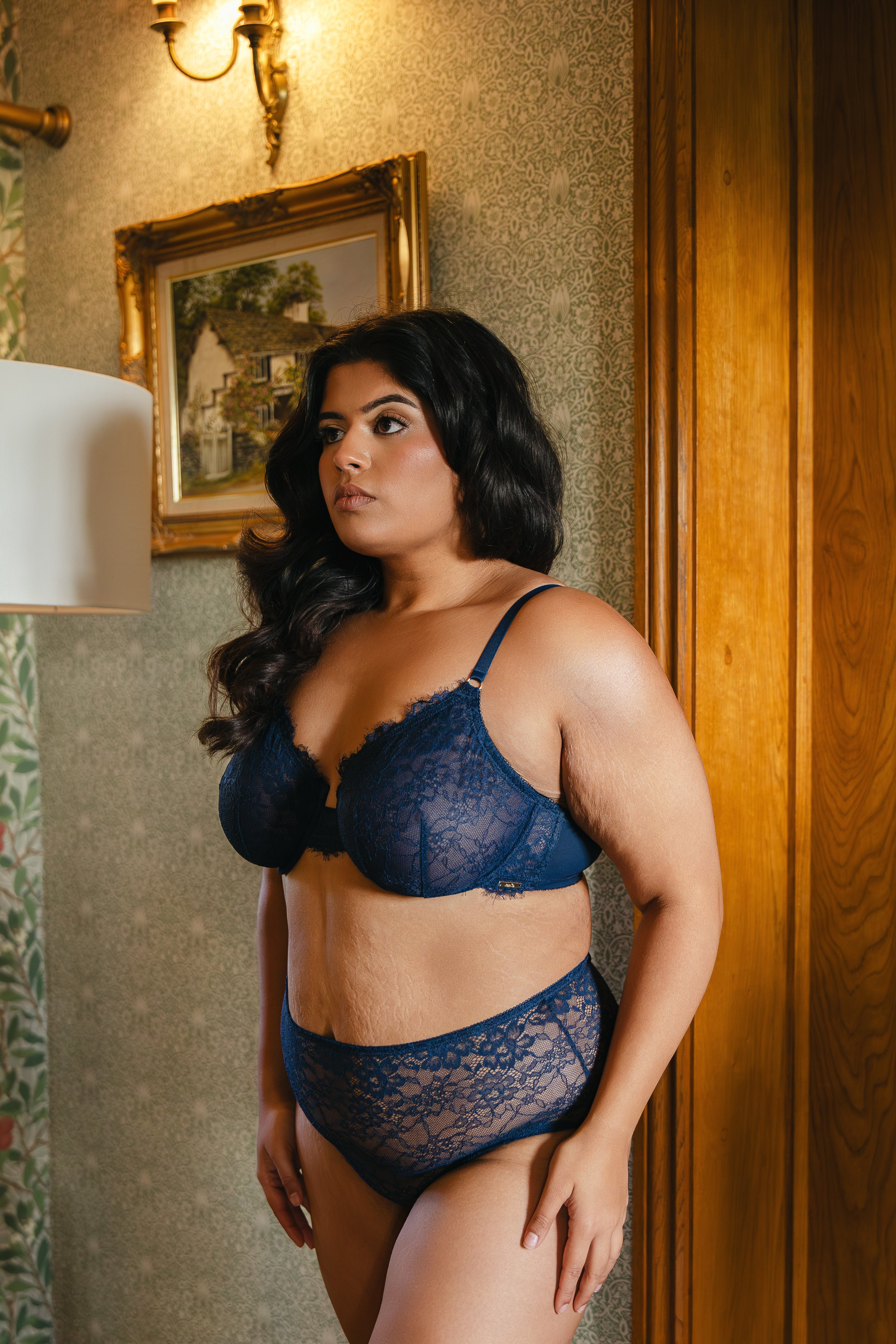 Model wearing midnight blue lace underwired bra and lace boyshort lingerie set