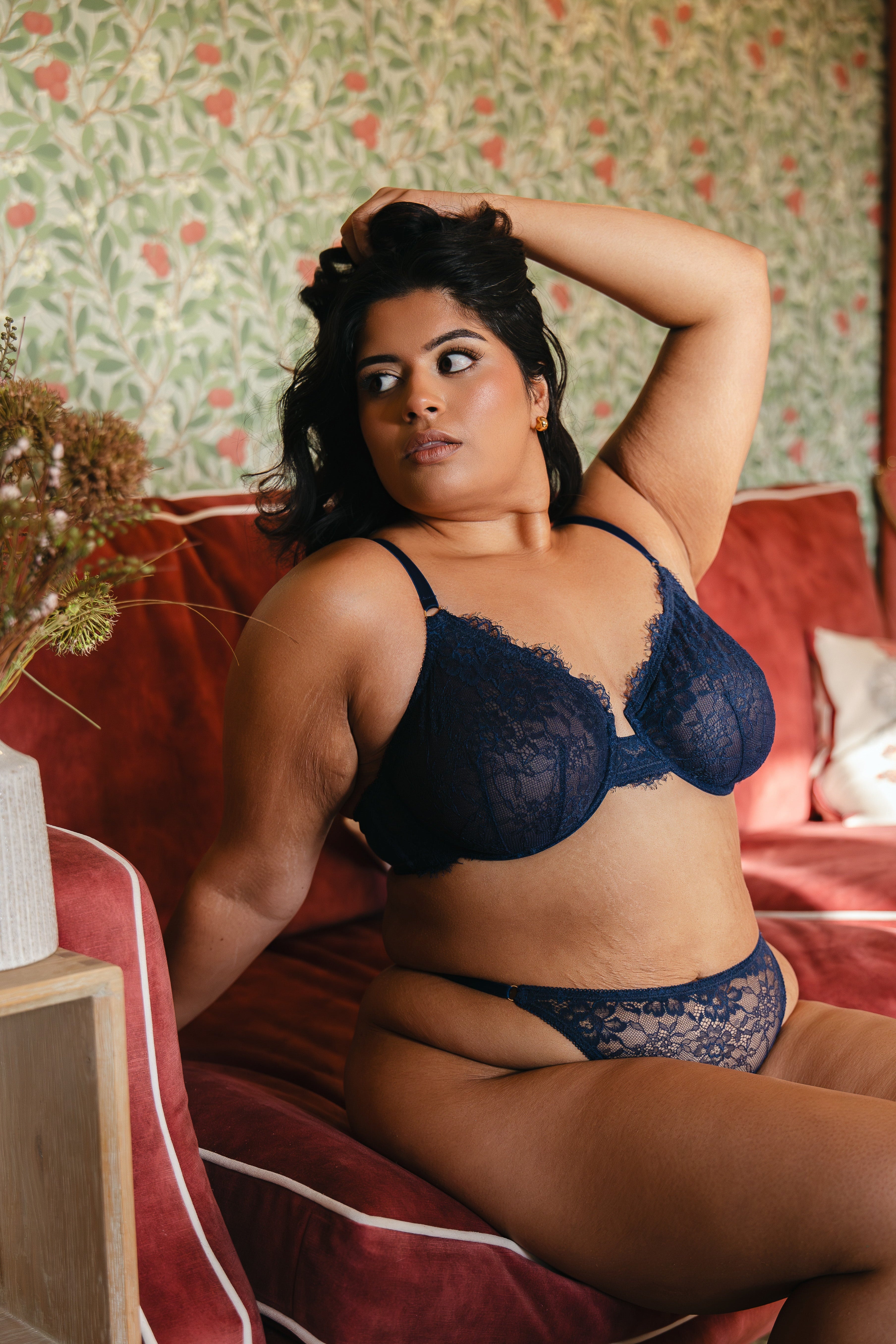Model wearing midnight blue lace underwired bra and lace thong lingerie set