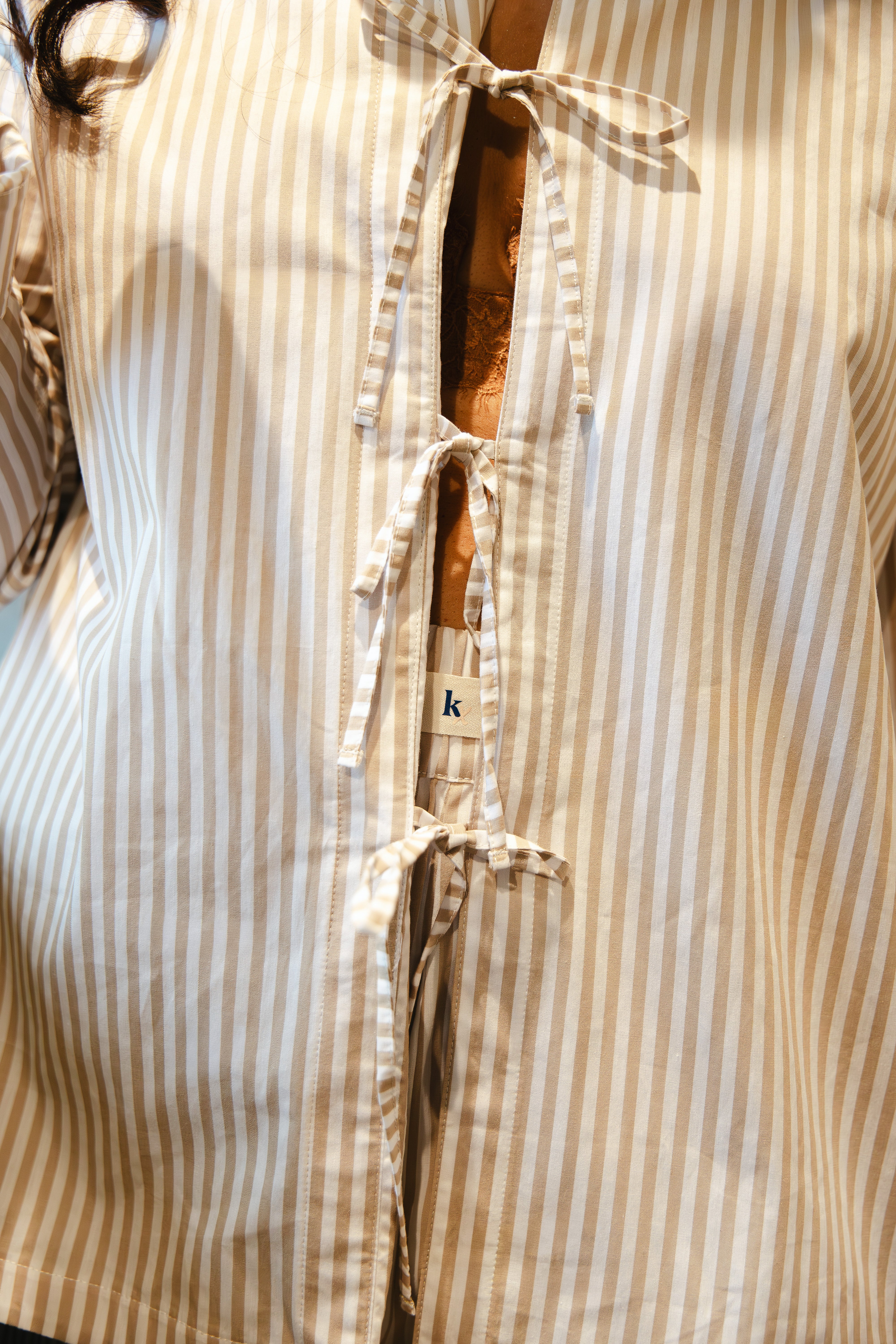 Model wearing pyjama neutral stripe long sleeve tie top